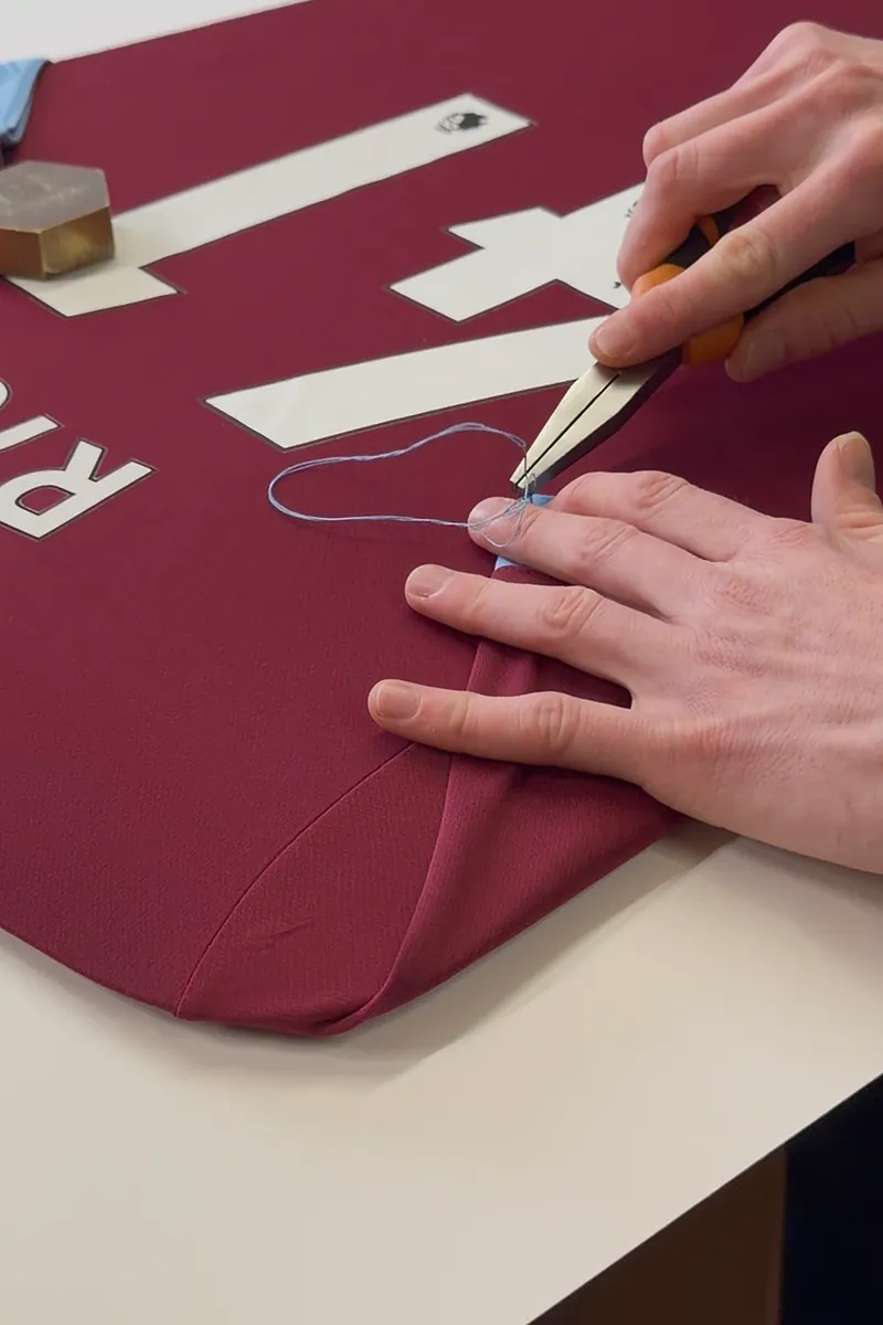 Hand-stitching a Declan Rice shirt onto its mount